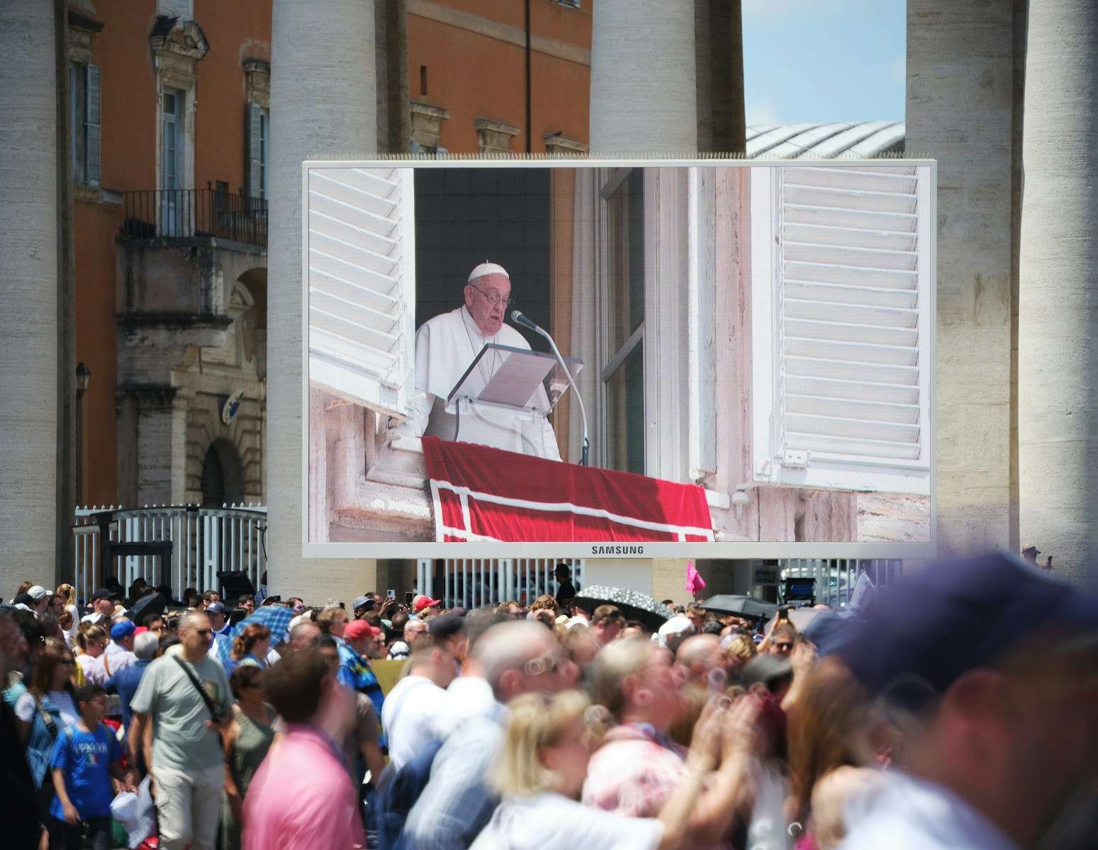 The pope is speaking to a large crowd.